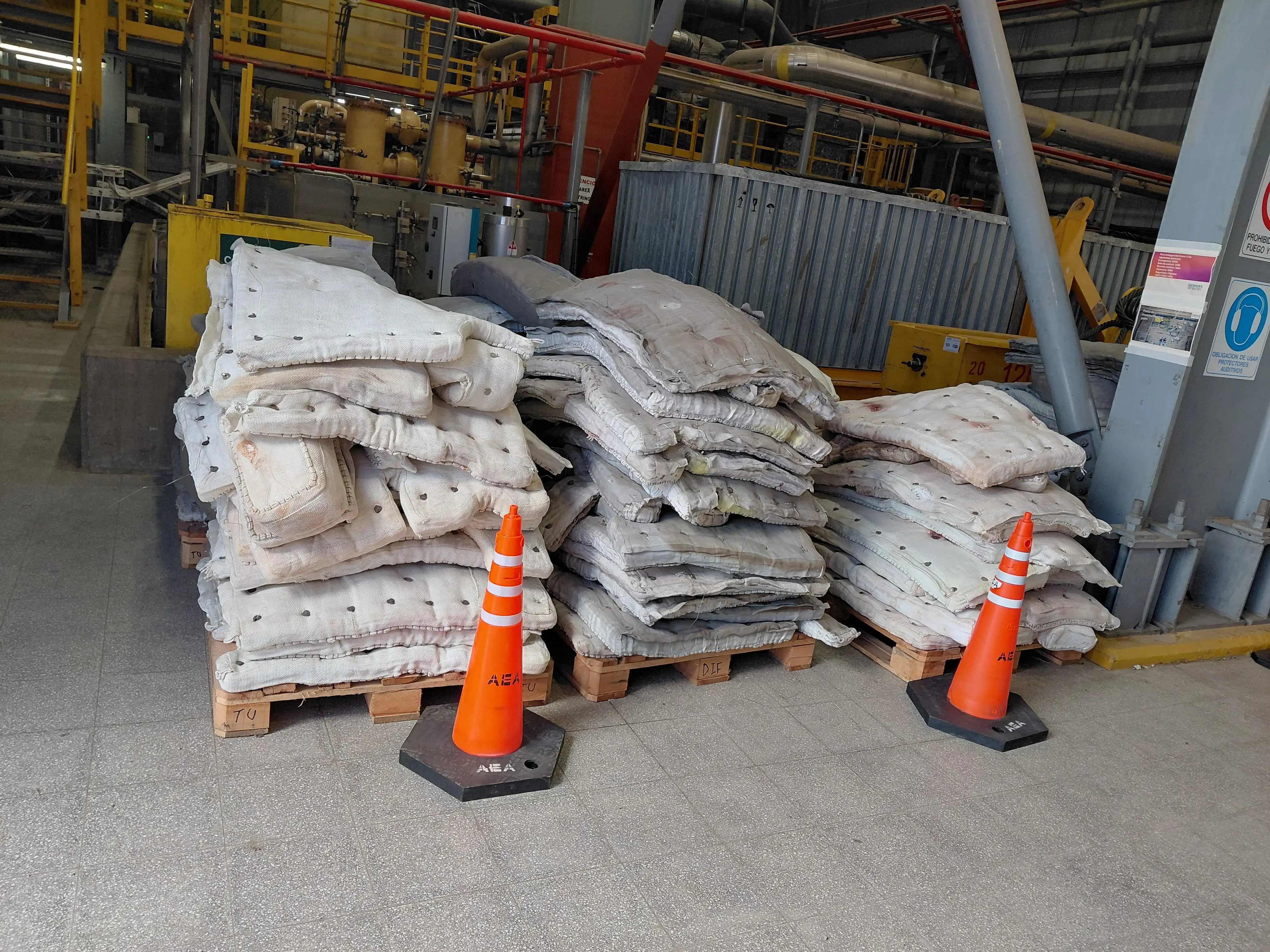 Stock de mantas de aislamiento térmico industrial apiladas en pallets, listas para instalación – Aislaciones DM